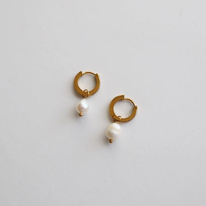 Flat view of Gold CZ Huggies with Pearl Drop showcasing the side profile details.